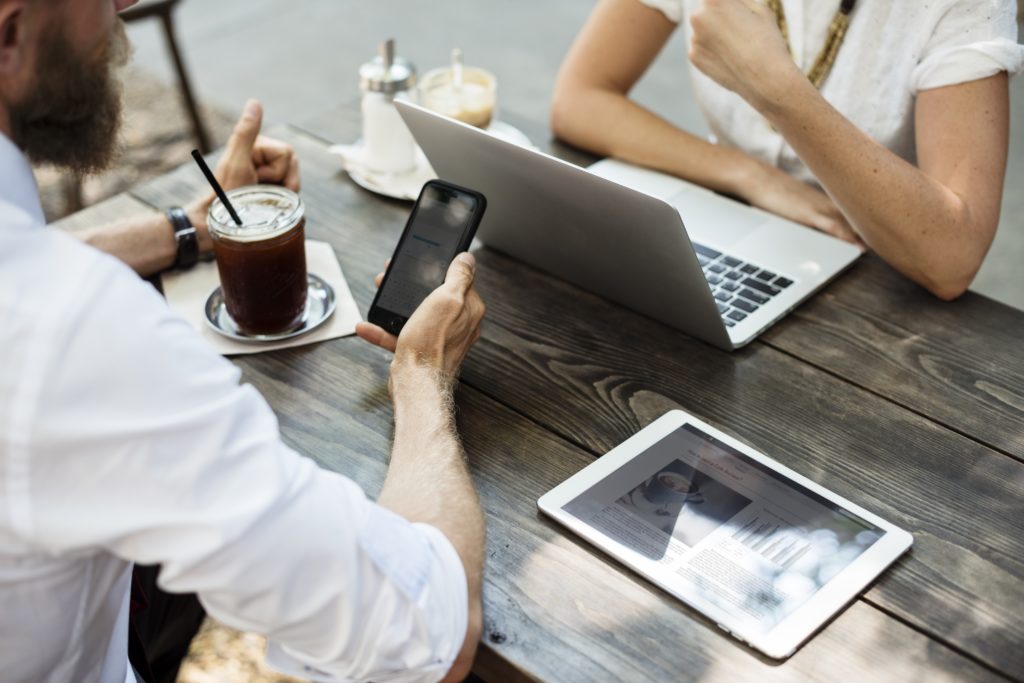 people meeting with smartphone, laptop, and tablet