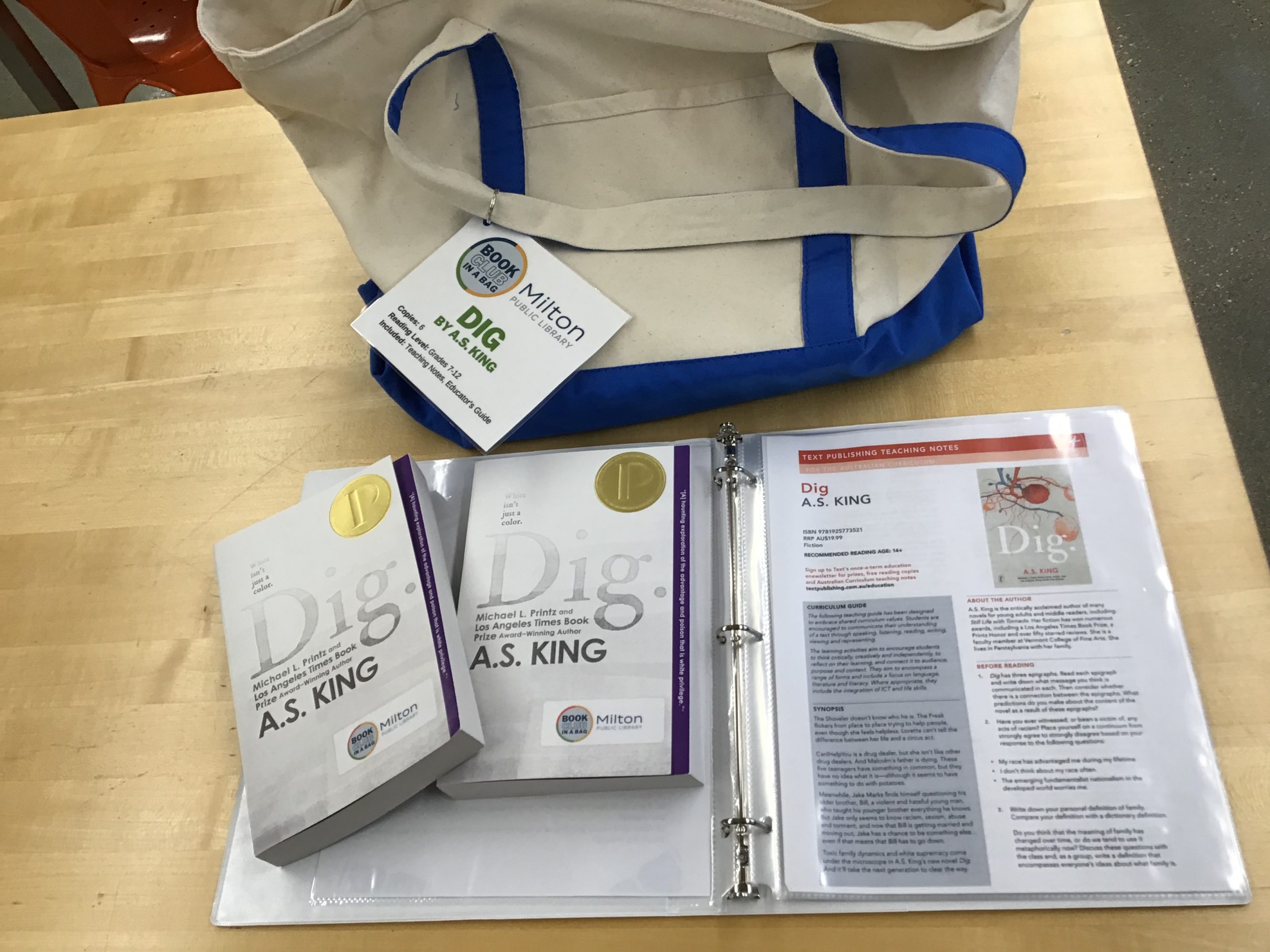 Canvas tote bag with two copies of Dig displayed over the book club kit binder.