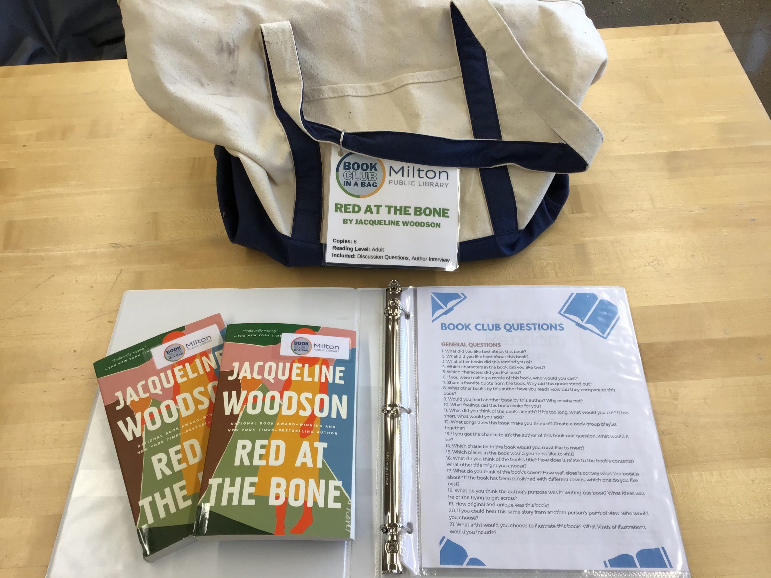 Canvas bag with two copies of Red At the Bone displayed on top of the book club notes.