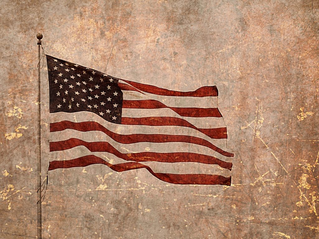 American flag waving in the wind with an antique patina overlay.