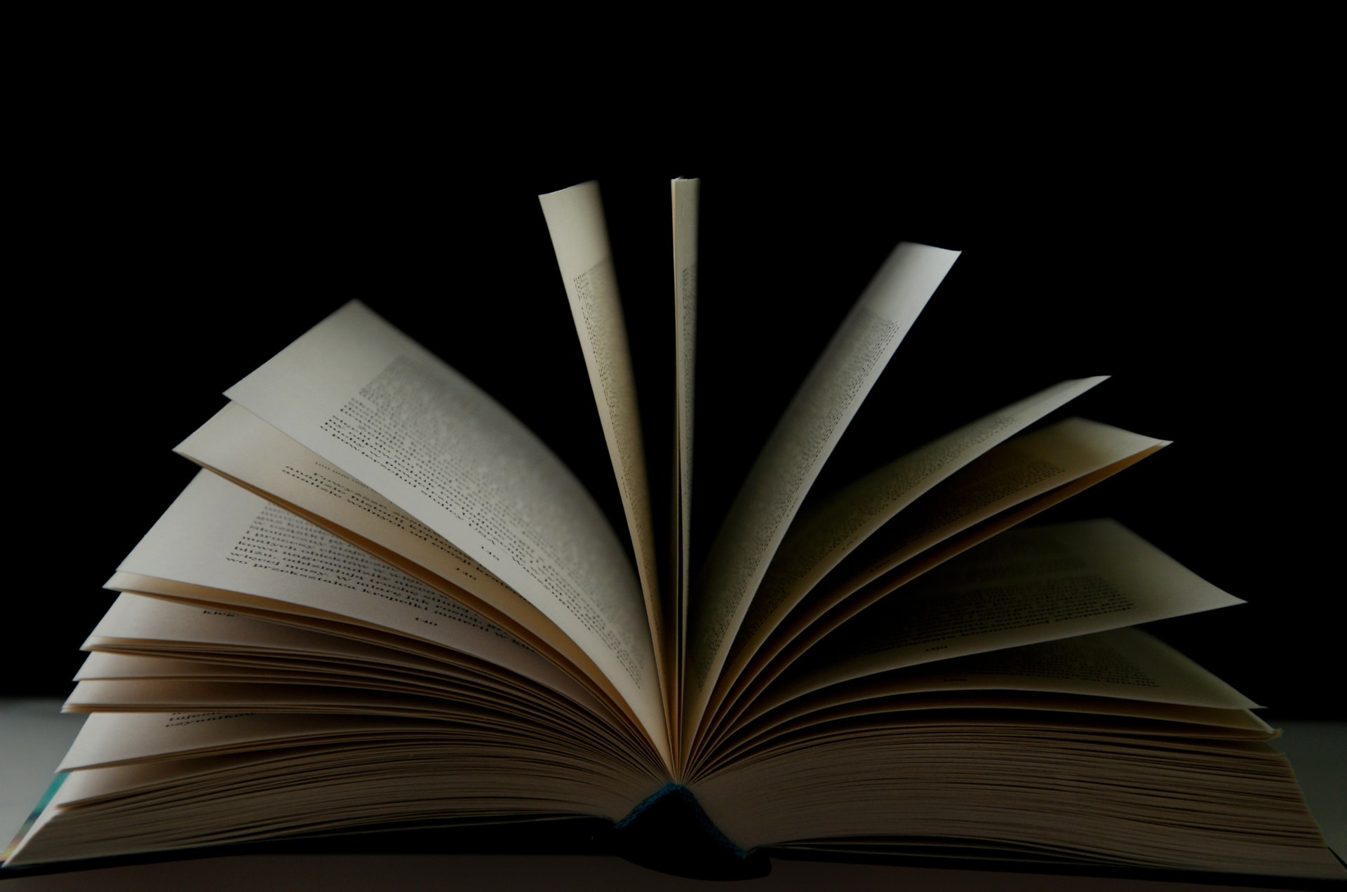 A book is open on a table with all of the pages sitcking out.