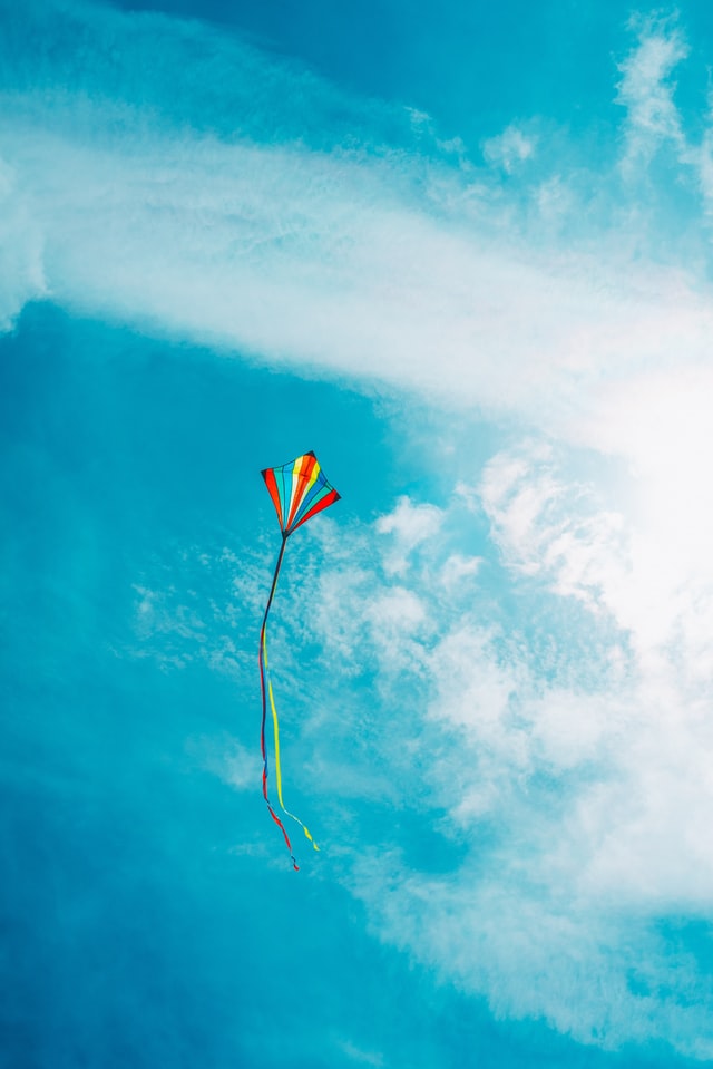 A colorful kite high in the blue sky.