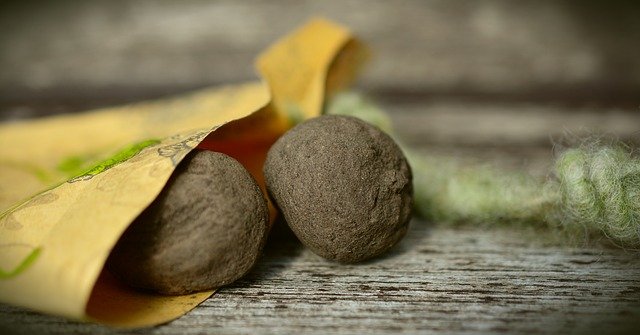 Two seed bombs on a wooden table.