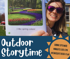 A picture of Jayme holding up a book, reading outdoors.