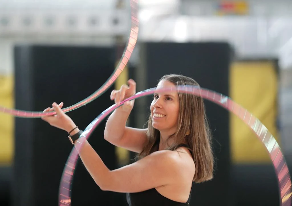 Danielle Lee spinning hula hoops in both hands.