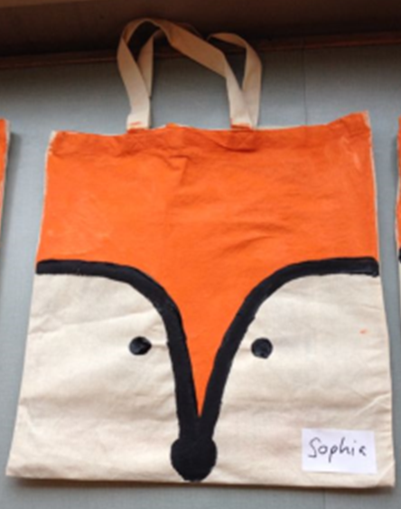 Tote bag painted with orange and black to resemble a fox.