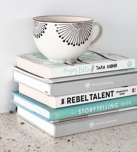 A stack of books with a coffee mug on top.