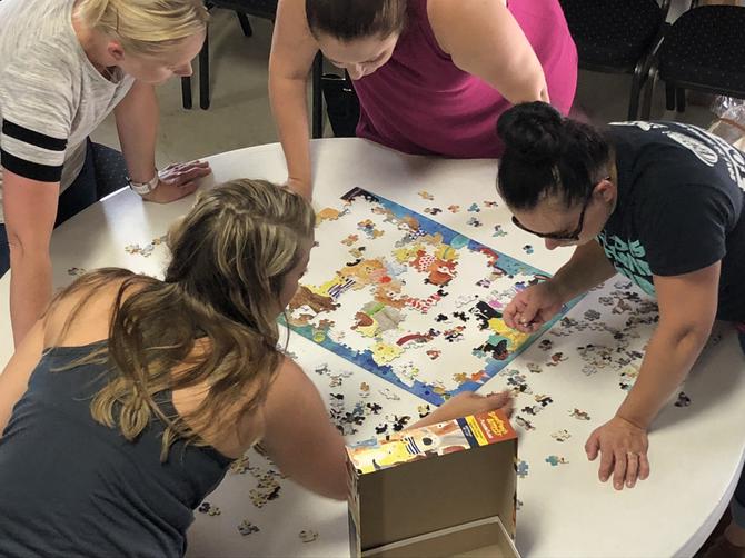A group of people working on a jigsaw puzzle together