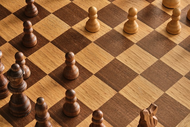 Picture of a wooden chess board with wooden pieces.