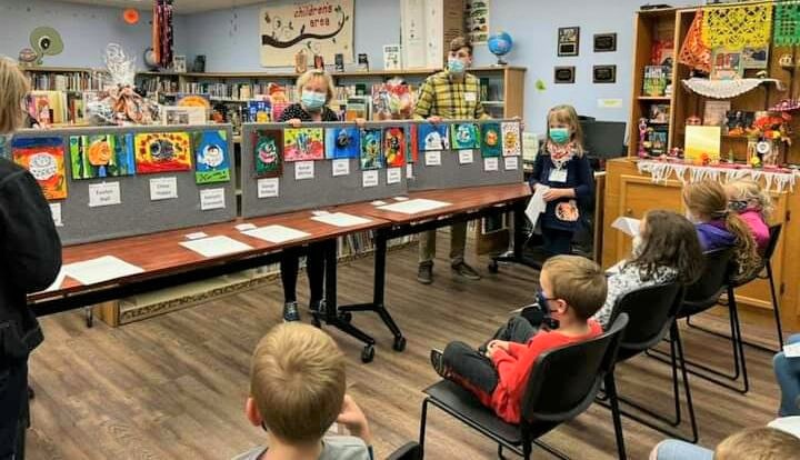 Children and adults viewing an exhibit of pop can dogs and cats in the Clinton Public Library.