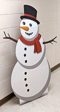 Cardboard standup of a generic snowman with stick arms, coal buttons, carrot nose, top hat, and red scarf.