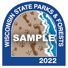 Wisconsin state parks and forrests 2022 sticker sample. Features and illustrated sand beach with human and animal footprints in the sand and waves lapping against the shore.